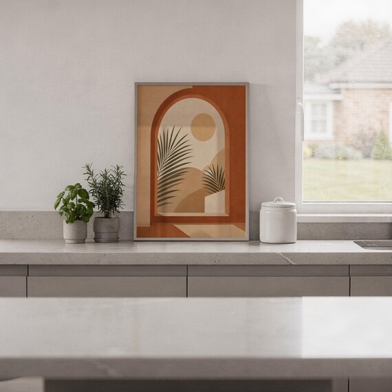 Minimalist terracotta arch print framed on white kitchen counter against clean wall decor.