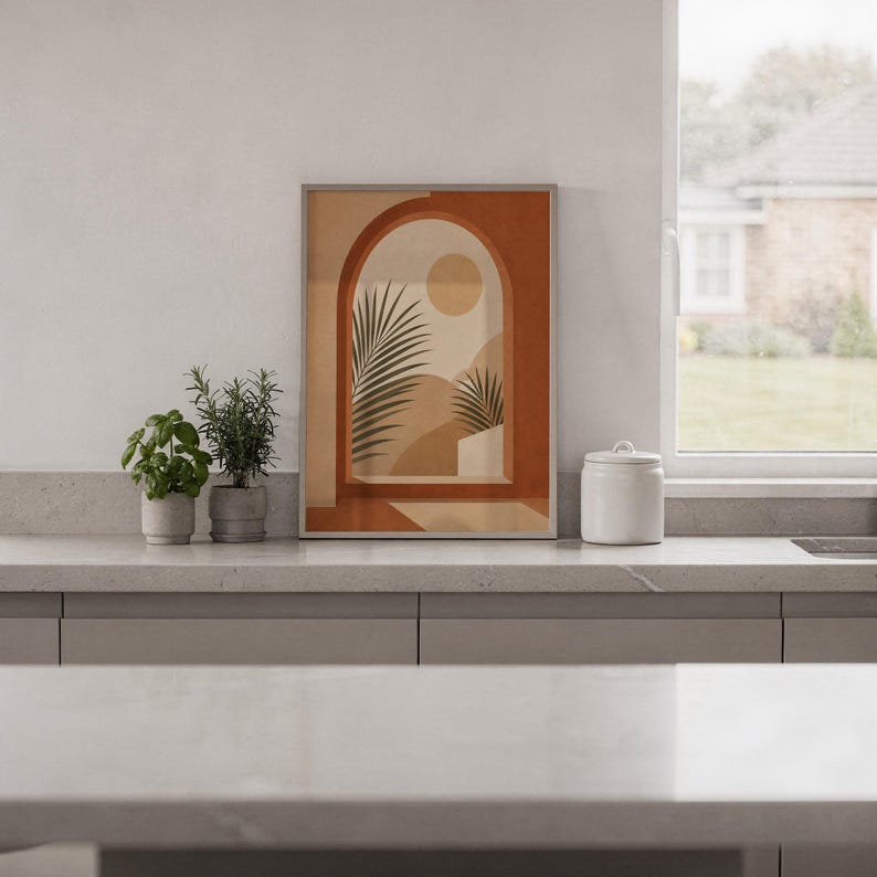 Minimalist terracotta arch print framed on white kitchen counter against clean wall decor.
