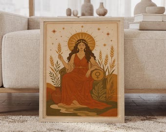 May include: A framed wall art print featuring a seated figure in a long rust-colored dress, holding a stalk of wheat. The figure has a star-adorned crown and a sunburst halo. A circular symbol of Venus is visible on the chair, surrounded by wheat stalks.