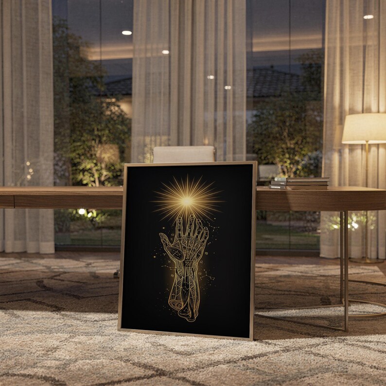 Celestial hand wall art print standing on a wooden desk in a home office in warm evening light.