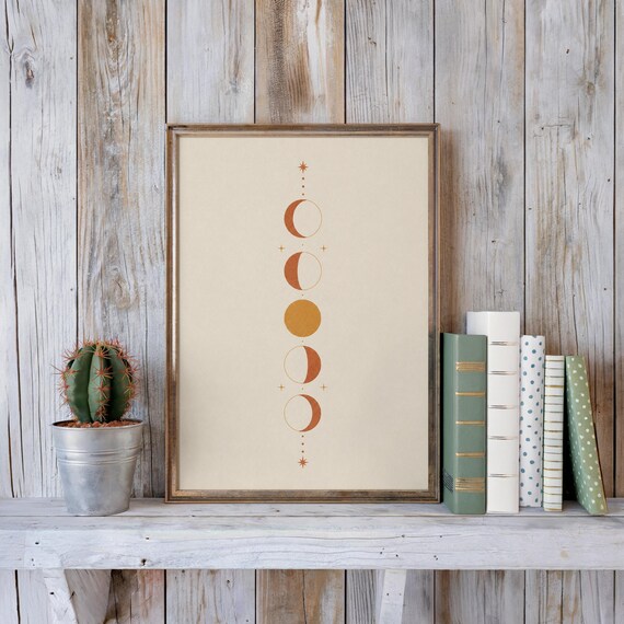 Mystical vertical moon phases poster on rustic shelf with books and cactus