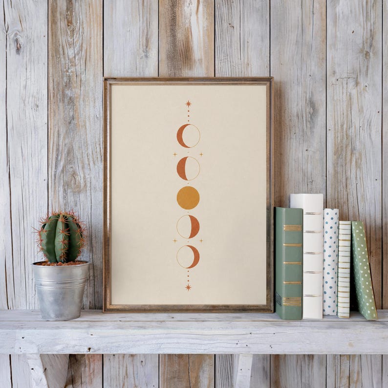 Mystical vertical moon phases poster on rustic shelf with books and cactus