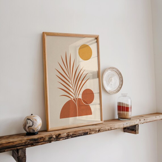 Warm earthy palm leaf art displayed on rustic wooden shelf in bright room