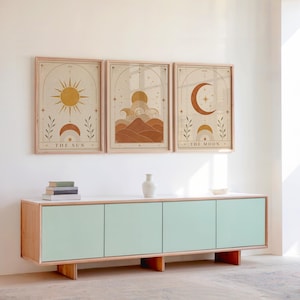 Set of 3 framed boho celestial art prints displayed above a wooden sideboard console.