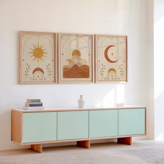 Set of 3 framed boho celestial art prints displayed above a wooden sideboard console.