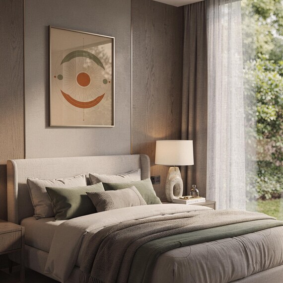 Abstract sun wall art print hanging above a bed with sage green pillows in a calm neutral bedroom.