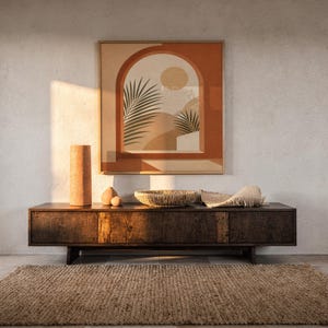 Terracotta arch window art framed on dark wooden console table in warm sunlit room decor.