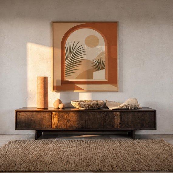 Terracotta arch window art framed on dark wooden console table in warm sunlit room decor.