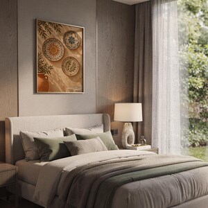 Mediterranean ceramic plate wall art print hanging above a bed with sage green pillows in a calm neutral bedroom.