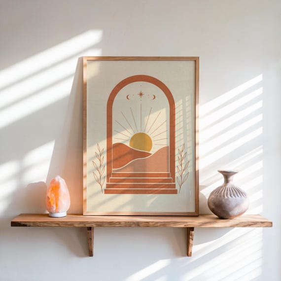 Desert sun landscape print framed on wooden shelf with warm sunlight shadows