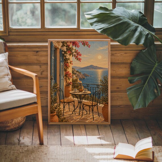 Mediterranean balcony wall art print leaning against warm wood paneling beside a wooden armchair and a monstera plant.