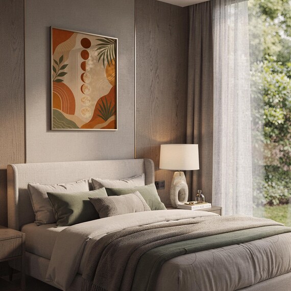Boho moon phases art print hanging above a bed with sage green pillows in a calm neutral bedroom.