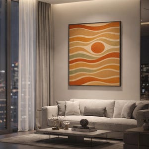 Abstract wavy sun print showing a wavy bands around a central sun circle in burnt orange, mustard, tan, cream and sage green, hanging above a light gray sofa in a modern living room with evening city views through tall windows.