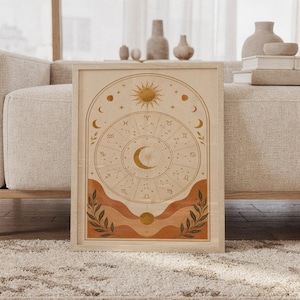 Zodiac wheel wall art print featuring warm ochre gold, terracotta, cream, and deep olive accents, celestial sun and moon motifs, zodiac symbols, and delicate constellation details in a vintage boho style, framed and leaning against a beige sofa on a textured rug in a bright Scandinavian living room.