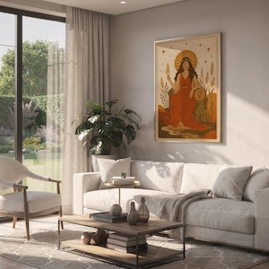 Celestial goddess wall art print hanging above a white sofa in a living room with garden views.
