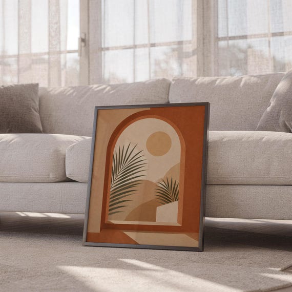 Terracotta botanical palm poster framed leaning against sofa in cozy sunlit living room setup.