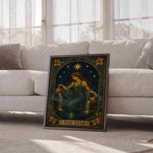 The star tarot card wall art print leaning against a white sofa in a bright living room with sheer curtains.