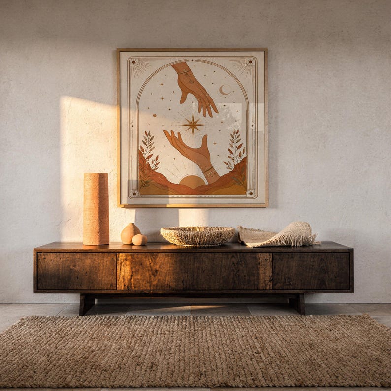 Terracotta spiritual hands tarot art framed on dark wooden console table in warm sunlit room.