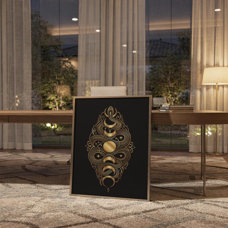 Gold snake moon phase wall art print standing on a wooden desk in a home office in warm evening light.