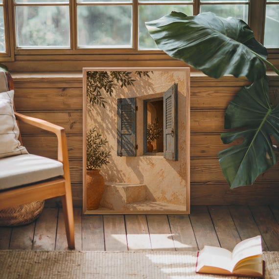 Mediterranean blue shutter wall art print leaning against warm wood paneling beside a wooden armchair and a monstera plant.