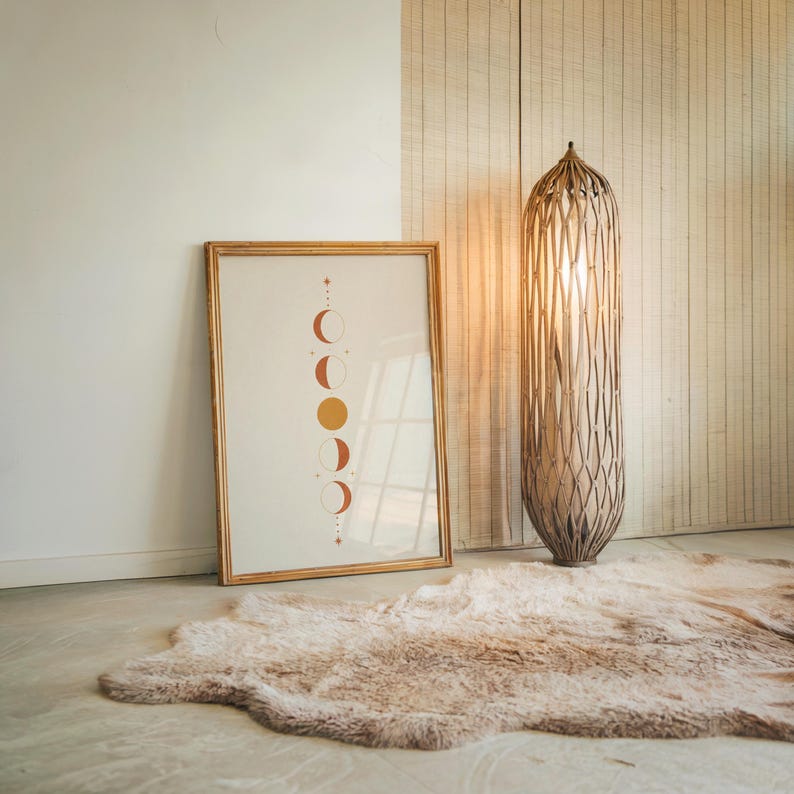 Boho celestial moon art resting on floor beside modern tall floor lamp
