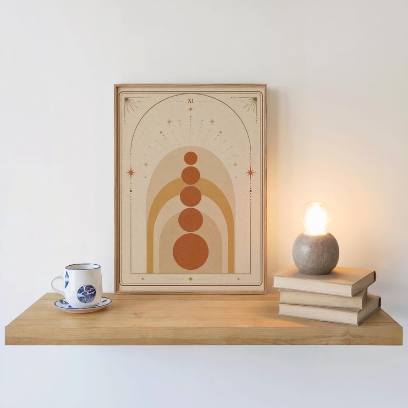 Terracotta arch art print on wooden floating shelf next to coffee cup and candle decor.
