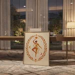 Framed spiritual celestial art poster leaning on the floor in a modern dining room setting with warm ambient lighting.