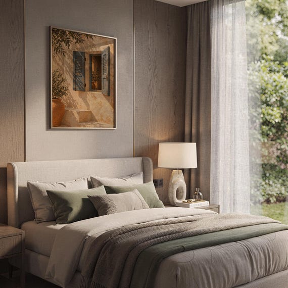 Mediterranean blue shutter wall art print leaning on a wooden desk against a warm beige wall in soft window sunlight.