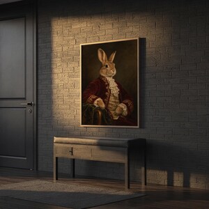 Regal rabbit portrait wall art print hanging above a stone countertop with a fruit bowl in a sunny kitchen.