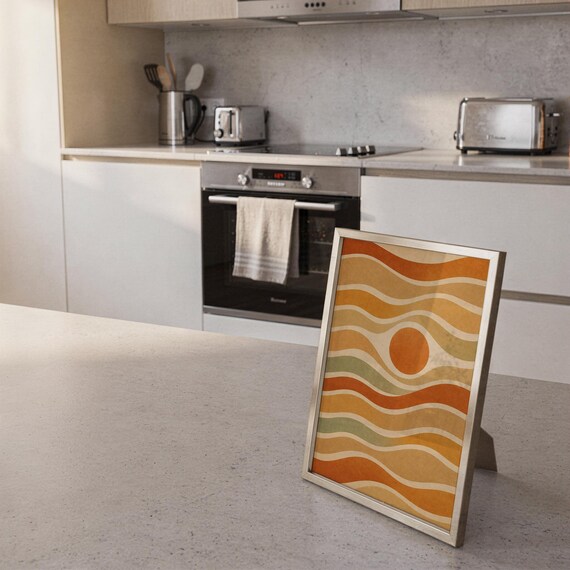 Abstract wavy sun print standing on a countertop in a modern white kitchen.