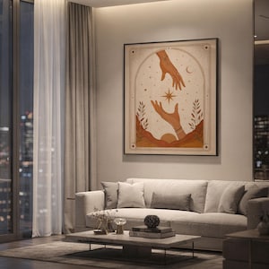 Terracotta spiritual tarot card print framed on wall behind white sofa in spacious modern apartment.