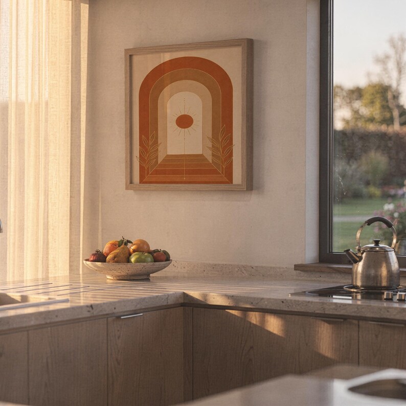 Boho arch sun wall art print hanging above a stone countertop with a fruit bowl in a sunny kitchen.