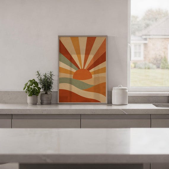 Retro geometric sunrise print standing on a white kitchen counter beside potted herbs.