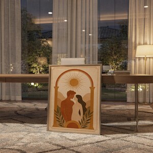 Framed bohemian art print placed on the floor in front of floor-to-ceiling glass patio doors during warm evening twilight.