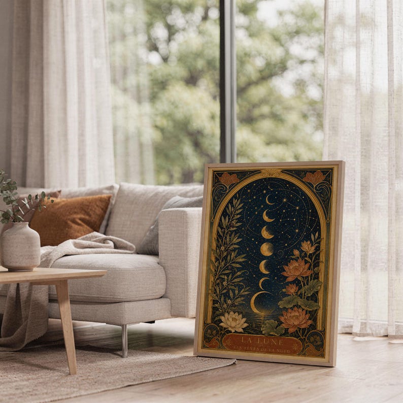 Moon phase wall art print leaning on the floor beside a cream armchair next to large garden windows.