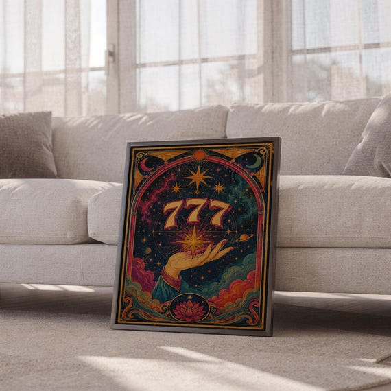777 angel number wall art print leaning against a white sofa in a bright living room with sheer curtains.