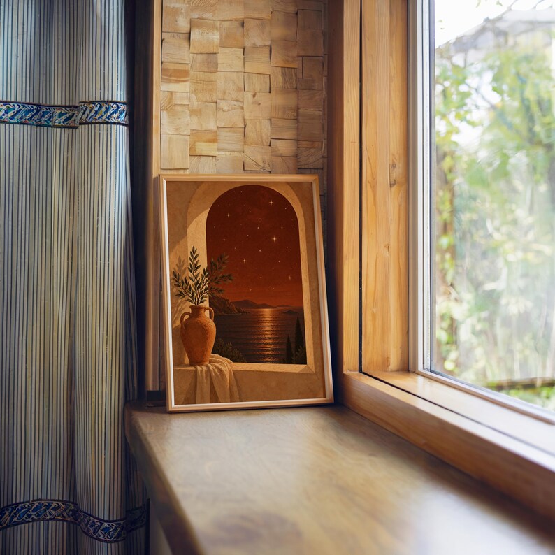 Mediterranean night sea wall art print standing on a wooden window sill in warm natural light.