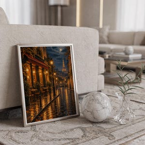Paris eiffel tower wall art print in a silver frame leaning against a sofa beside a decorative marble sphere.
