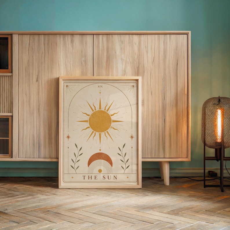 Single framed The Sun tarot card art print standing in front of a wooden credenza.