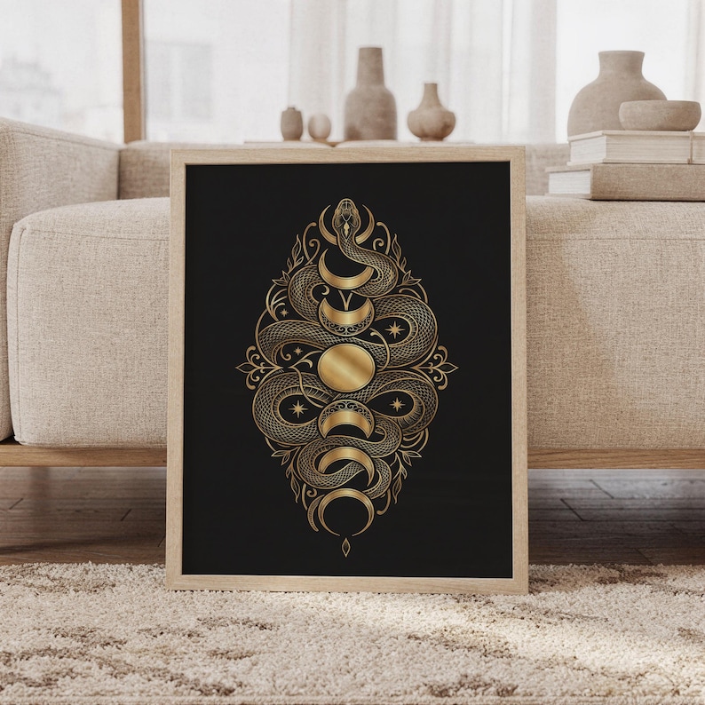Gold snake moon phase wall art print featuring intricate metallic gold snakes, crescent moons, stars, and ornamental botanical details on a deep black background, framed and leaning against a beige sofa on a textured rug in a bright Scandinavian living room.