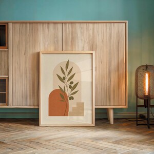 Olive branch artwork resting on floor against light wood accent wall
