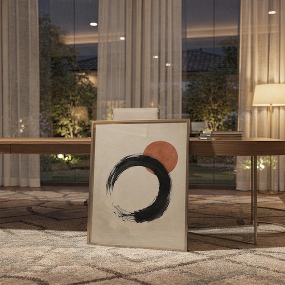 Framed zen circle poster leaning on a shelf in a warm, ambient-lit office or study.