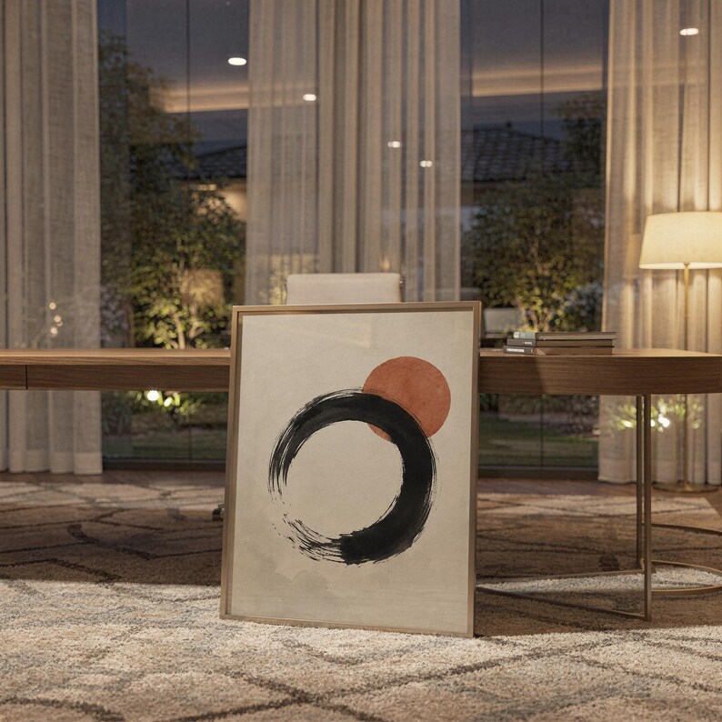 Framed zen circle poster leaning on a shelf in a warm, ambient-lit office or study.