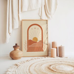 Desert oasis wall art poster placed on floor with large floor cushions and vase