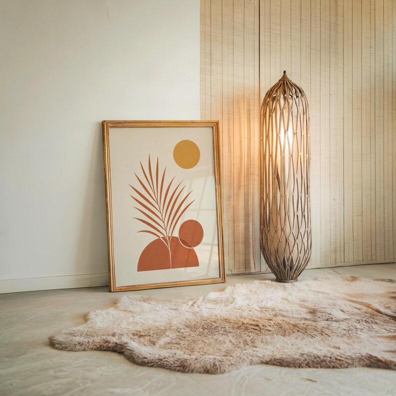 Large palm leaf wall art poster resting on floor next to tall floor lamp