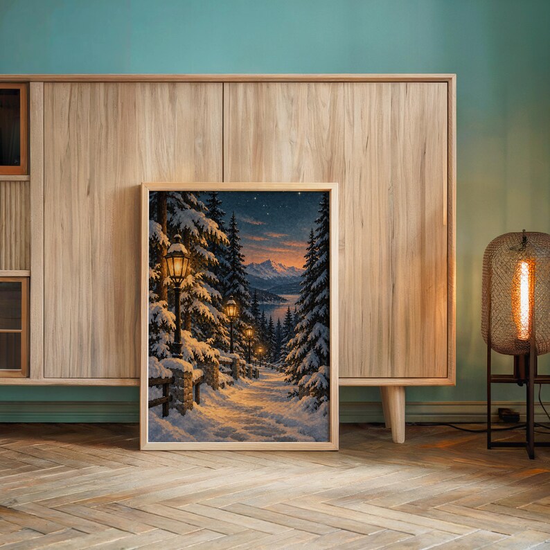 Snowy forest path wall art print leaning against a wooden cabinet by a teal wall beside a glowing floor lamp.
