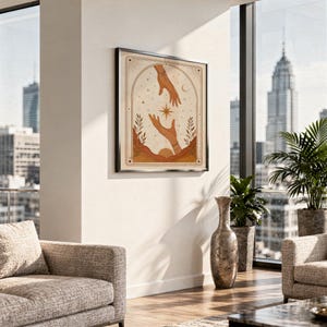 Terracotta celestial hands art print framed on wall above sofa in modern high rise apartment.