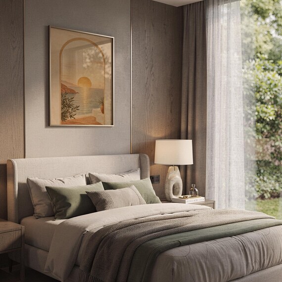 Mediterranean sunset arch print hanging above a bed with sage green pillows in a calm neutral bedroom.