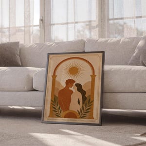 Boho romantic arch print in a light wood frame resting on a soft rug next to a white sofa in a sun-drenched modern apartment.