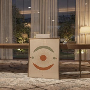 Abstract sun wall art print standing on a wooden desk in a home office in warm evening light.